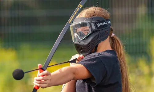 Joueur équipé d’un masque et d’un arc pour l’Archery Tag