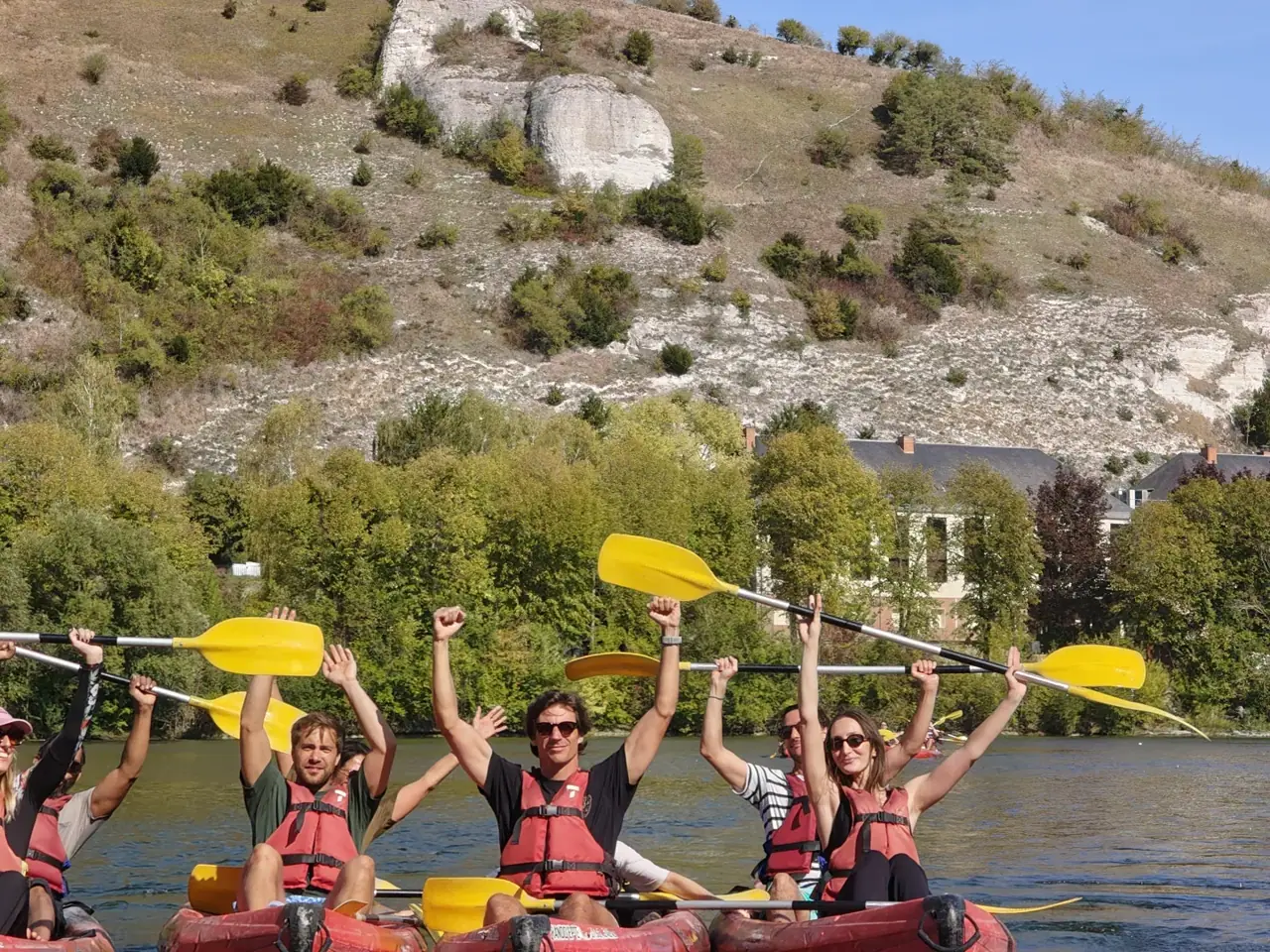 Participants en kayak levant leurs pagaies après une sortie en équipe
