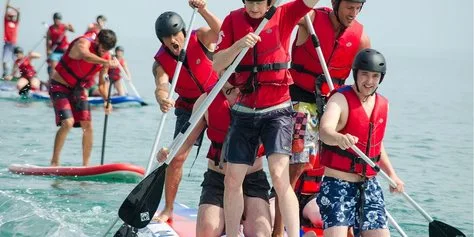 Participants sur un stand up paddle géant