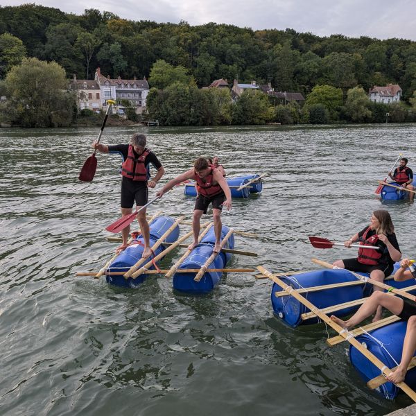 &Eacute;quipe pagayant sur un radeau construit pendant l&rsquo;activit&eacute; d&eacute;fi radeau
